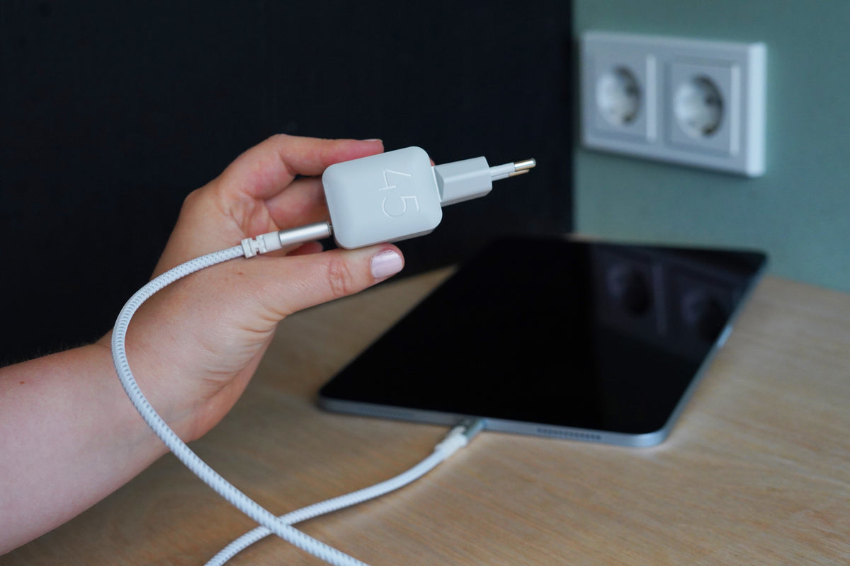 Witte NextGen 45W-snellader in het stopcontact, met de kabel naar een tablet
