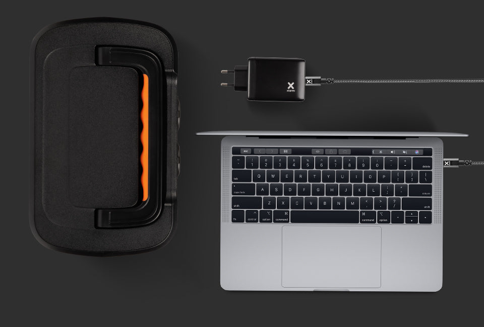 Xtorm-lader met kabel naast laptop en powerstation: laag 4, bescherming tegen kortsluiting